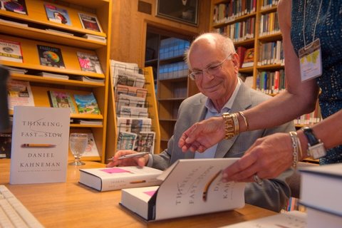 Daniel Kahneman signs copies of "Thinking, Fast and Slow" in CASBS's library reading room in 2013. [CASBS files]