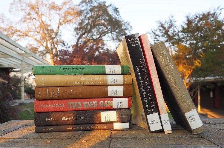 A stack of books by the recently deceased former fellows as of Fall 2018